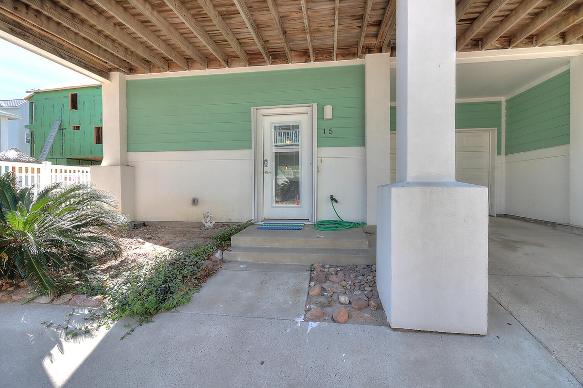 Charming beachside entrance with tropical touches and covered parking awaits your arrival.