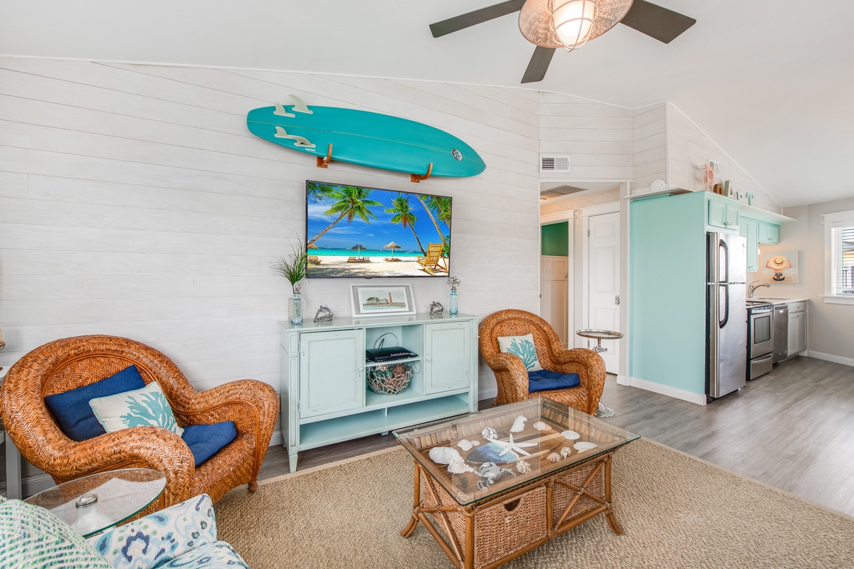 Your coastal retreat features wicker seating, beach-themed decor, and an open kitchen perfect for relaxing after sandy adventures.