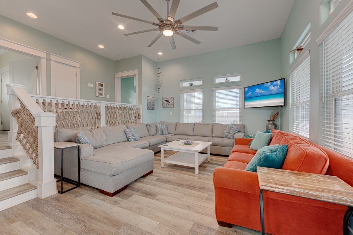 Unwind in your spacious living room with coastal-inspired décor, plush sectional seating, and modern amenities for perfect relaxation.