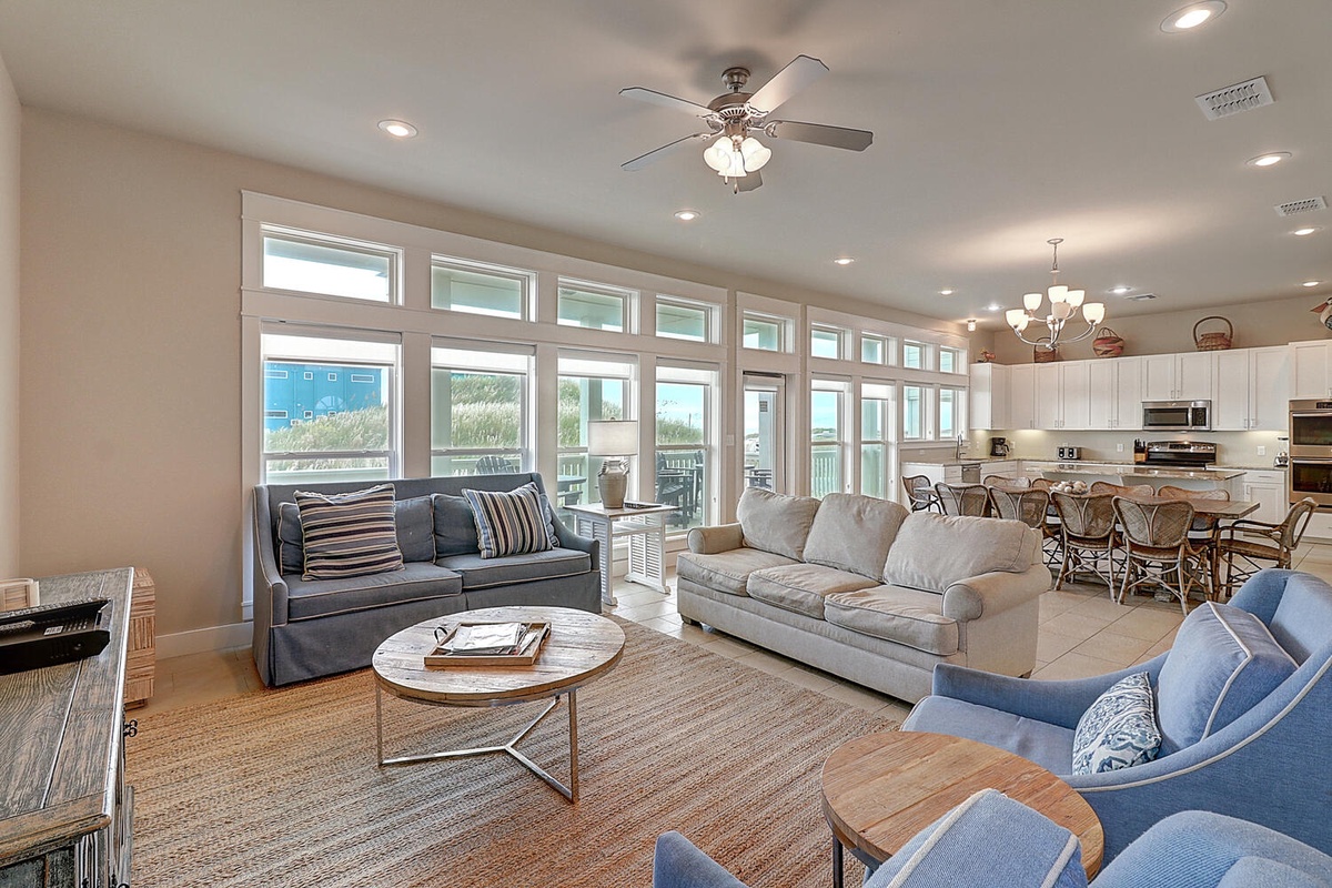 Unwind in your bright, spacious living room featuring plush sofas, coastal views, and seamless flow to the modern kitchen.