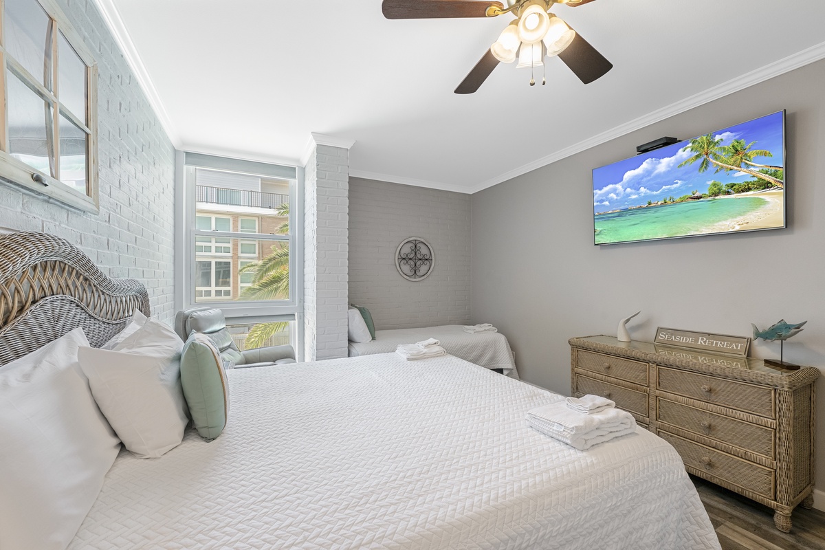 Drift off to sleep in your serene retreat with coastal touches and tropical views on the wall-mounted TV.