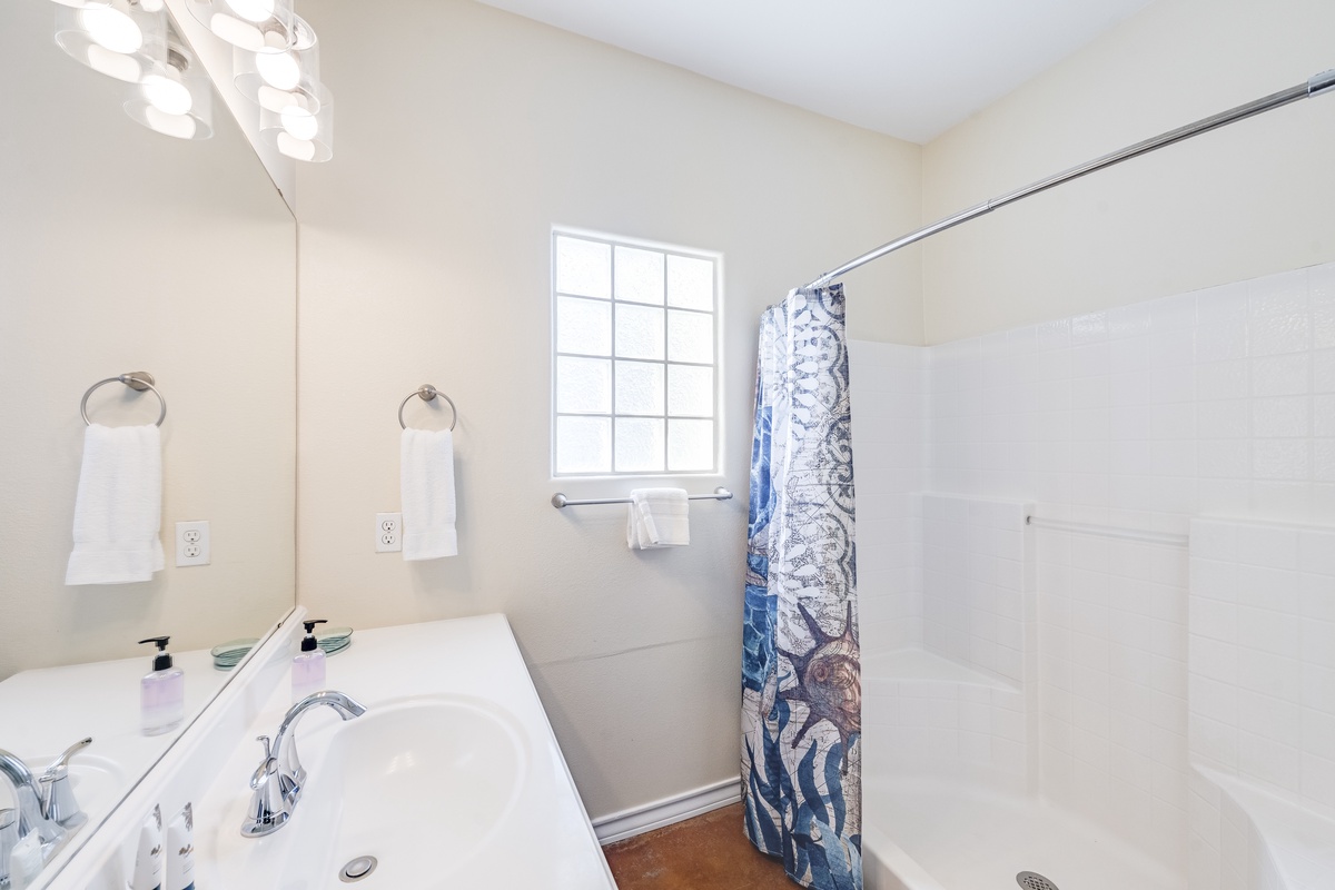 Refresh in your bright, clean bathroom with fresh towels and natural light streaming through the window.