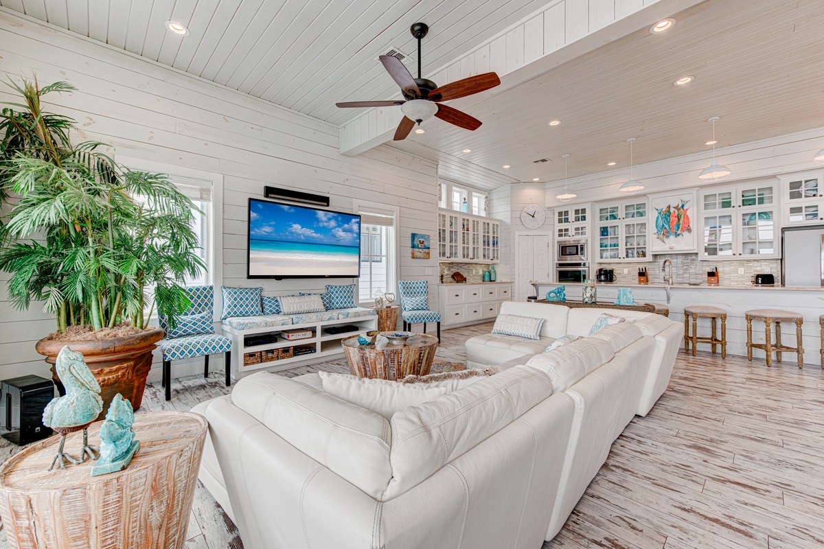 Sink into plush white sofas in this coastal-inspired great room, where shiplap walls and turquoise accents create your perfect beach house retreat.