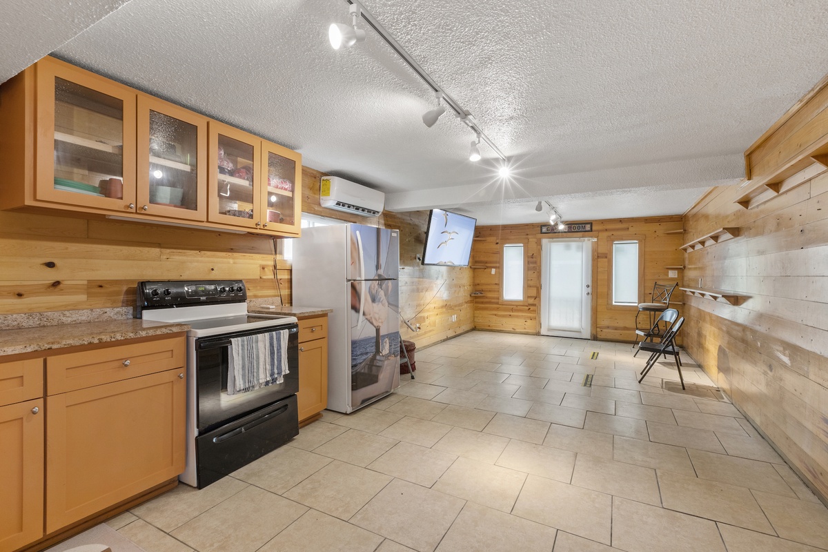 Third well equipped kitchen with granite countertops, modern appliances, and warm wood cabinetry.