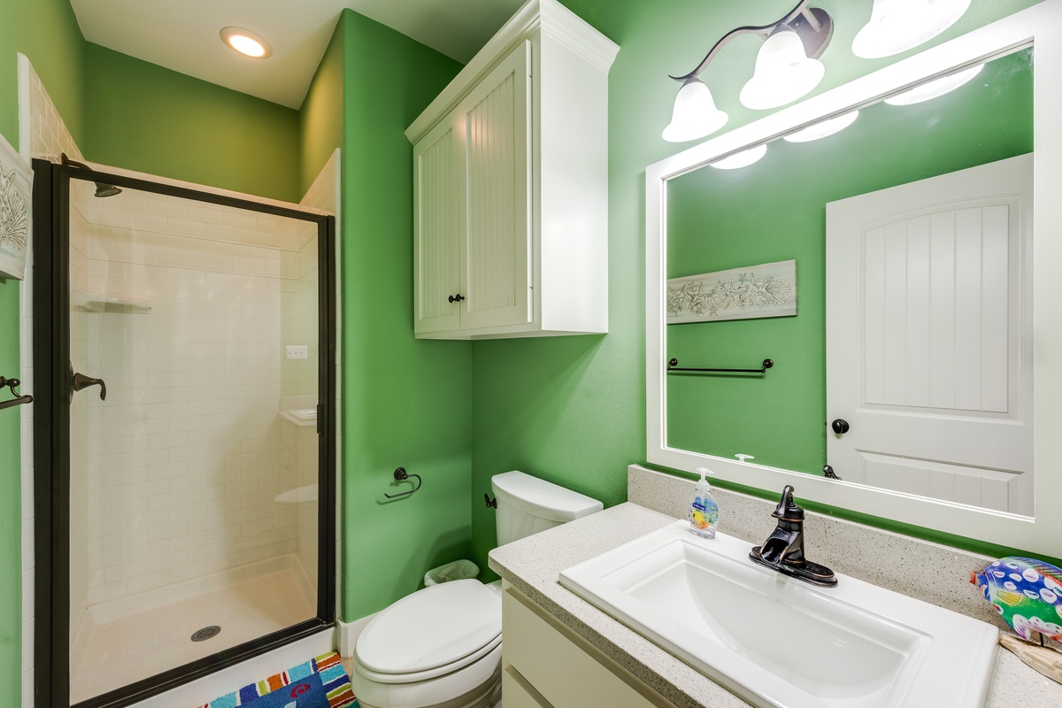 Step into your bright, cheerful bathroom featuring vibrant green walls, modern shower, and all essentials for a refreshing start to your day.