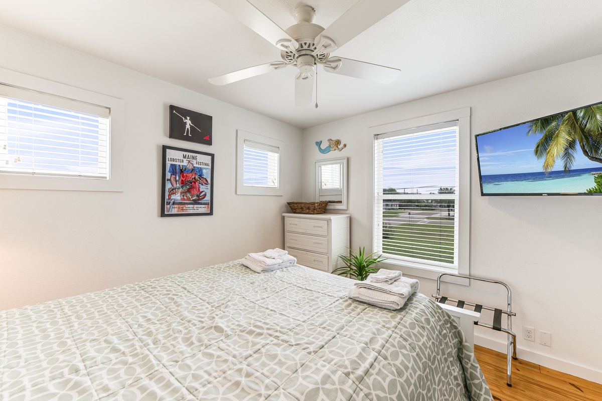 Rest easy in your bright bedroom with a comfy queen bed, ceiling fan to keep you cool, and beach-themed decor that sets a relaxing tone for your stay.