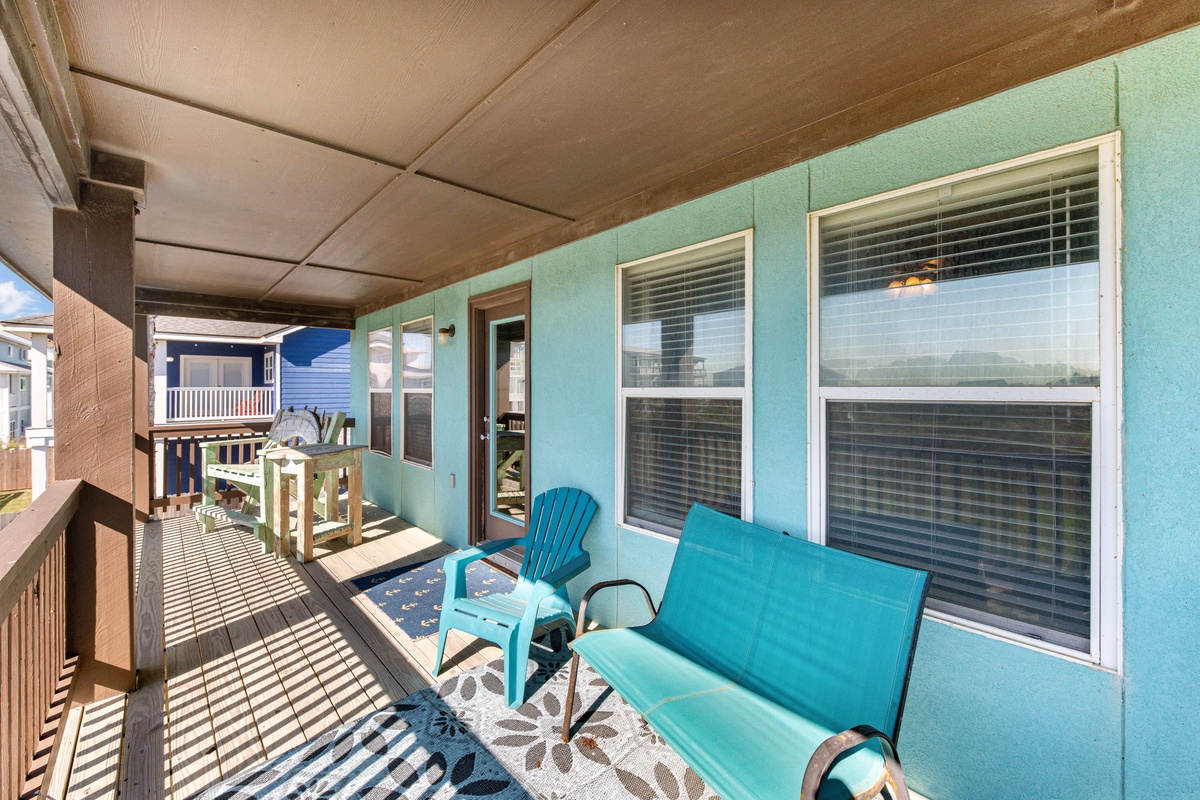 Relax on your covered porch with turquoise seating and ocean breeze filtering through.