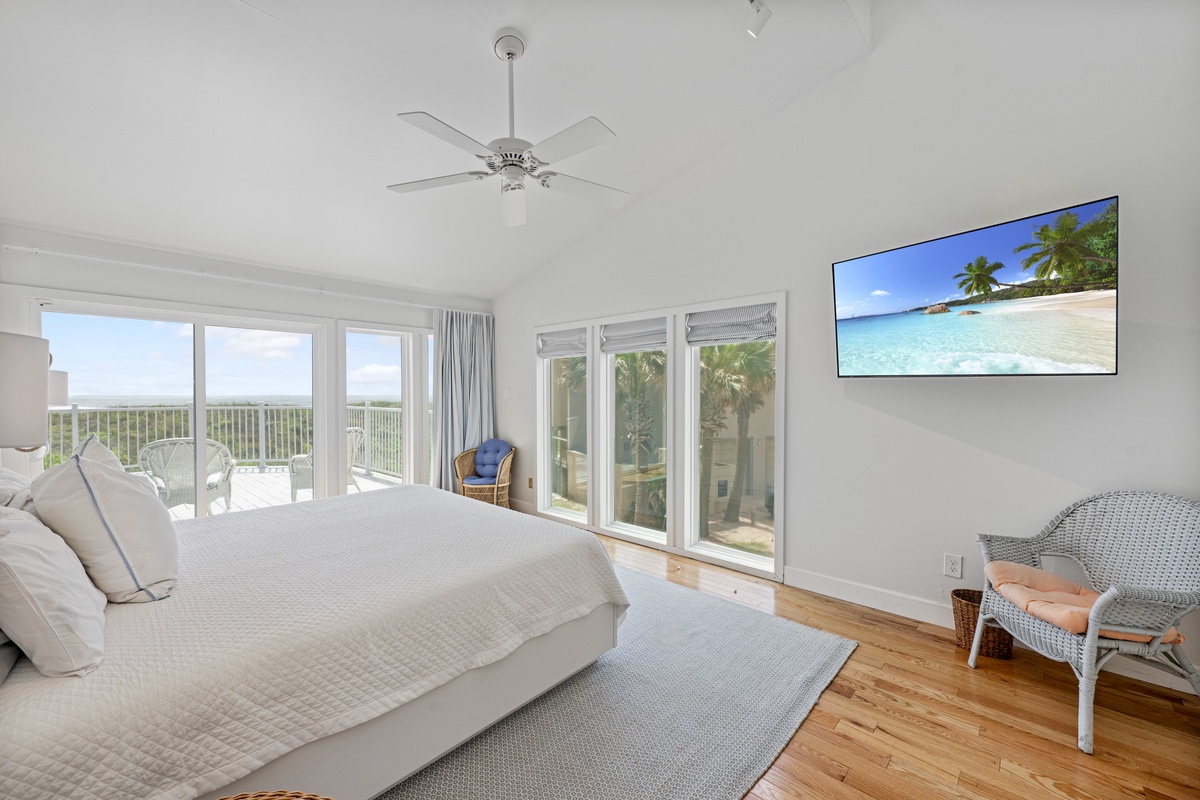 Wake up in this serene bedroom where floor-to-ceiling windows frame stunning views and coastal breezes flow through.