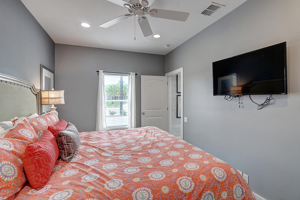 Rest in comfort with soft linens, gentle ceiling fan breezes, and your own wall-mounted TV for evening entertainment.