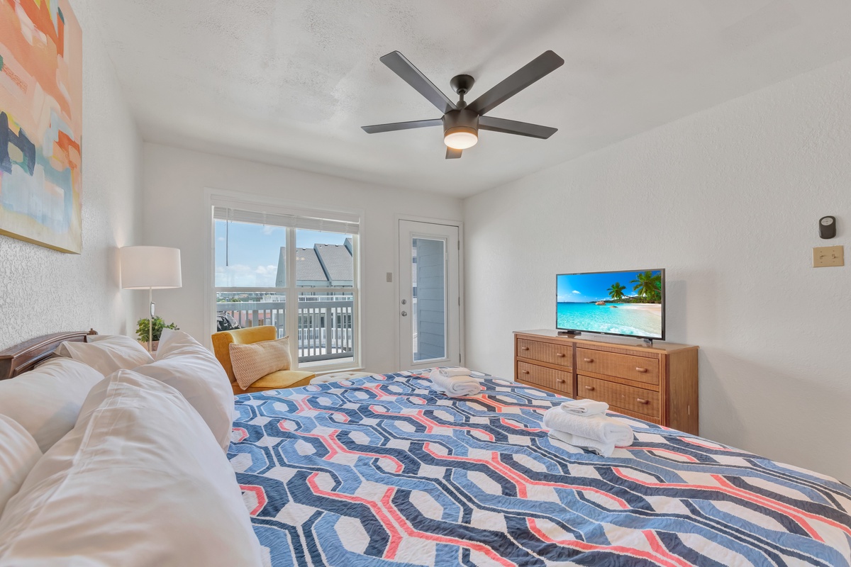 Drift off to peaceful slumber in your bright, airy bedroom with a cooling ceiling fan and balcony access to ocean breezes.