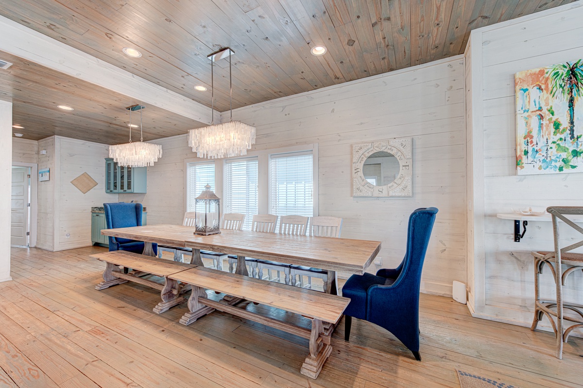 Gather around this stunning farmhouse dining table where rustic meets elegant. Crystal chandeliers illuminate family meals beneath soaring wood-paneled ceilings.