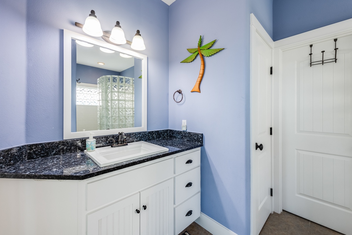 Step into your bright coastal bathroom with tropical touches and granite counters for your daily refresh.