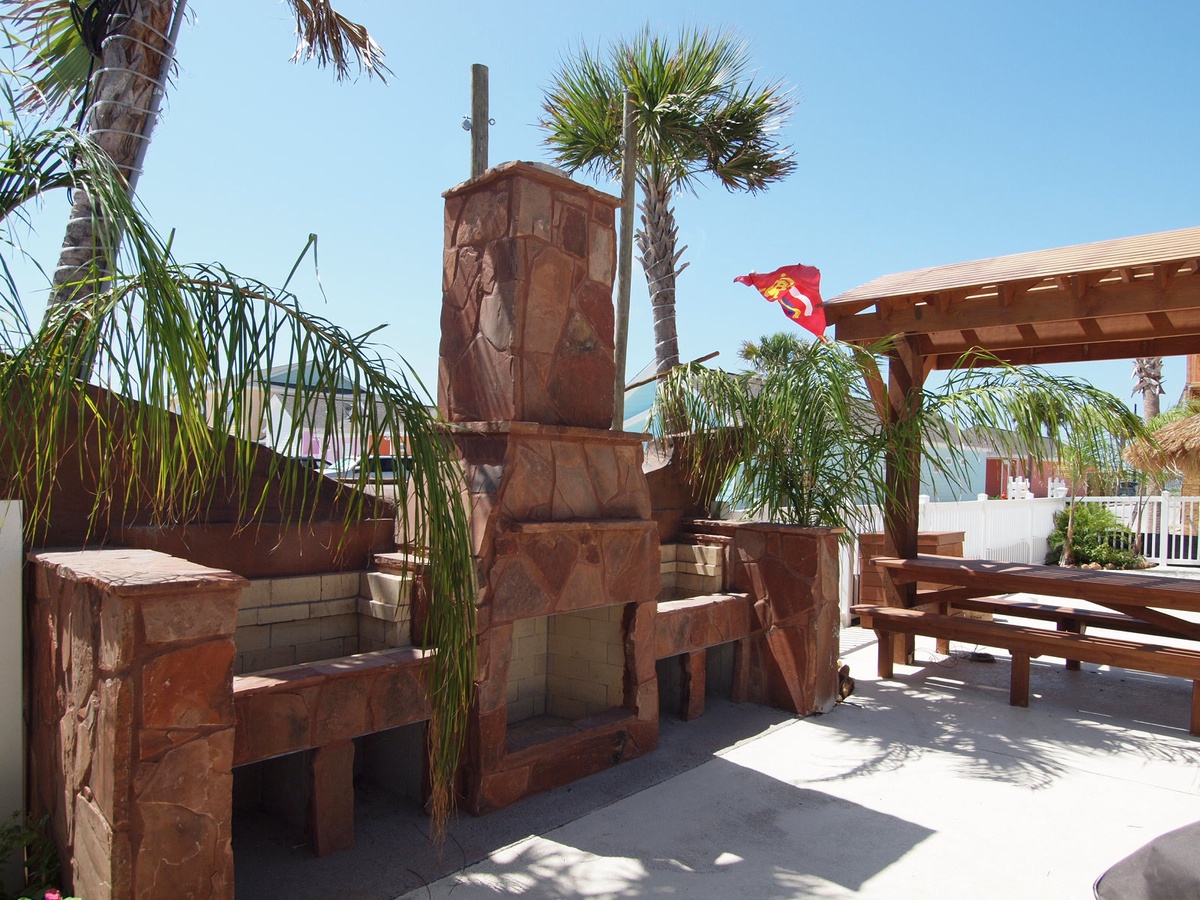 Your private outdoor fireplace creates the perfect gathering spot under swaying palms and sunny skies.