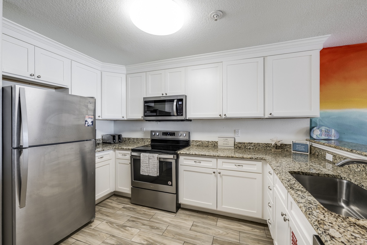 Your fully-equipped kitchen features sleek stainless steel appliances, granite countertops, and bright white cabinetry—perfect for preparing meals while you enjoy your vacation.