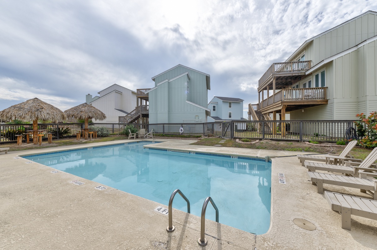 Dive into crystal-clear waters surrounded by charming beach houses, with loungers perfect for soaking up the coastal atmosphere.
