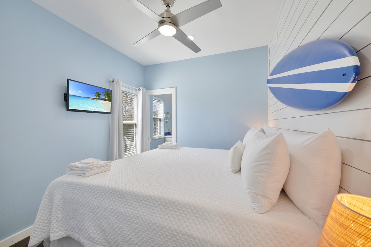 Your coastal bedroom sanctuary features crisp white linens and ocean hues, perfect for dreaming of beach days ahead.