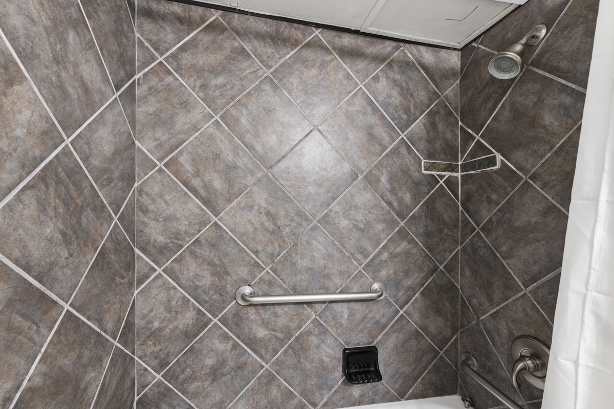 Step into your accessible walk-in shower with diagonal tile and convenient grab bars for safety and ease.