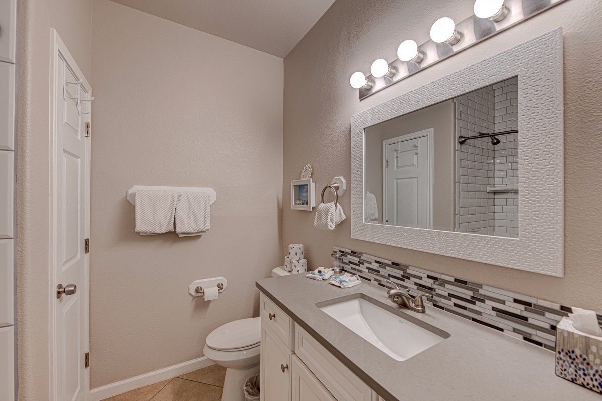 Your private bathroom features stylish tile details, modern vanity lighting, and fresh towels to start your day.