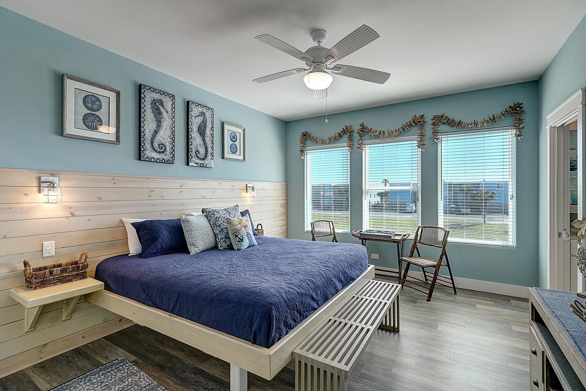 Wake up to ocean views through large windows in your coastal-themed bedroom with comfortable seating and relaxing nautical touches.