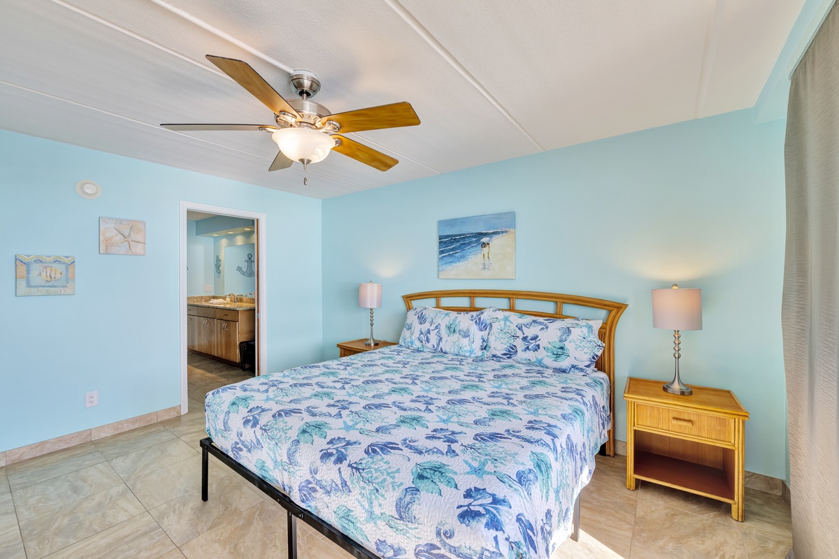 Your coastal bedroom awaits with soothing blue walls, tropical bedding, and a ceiling fan for comfort.