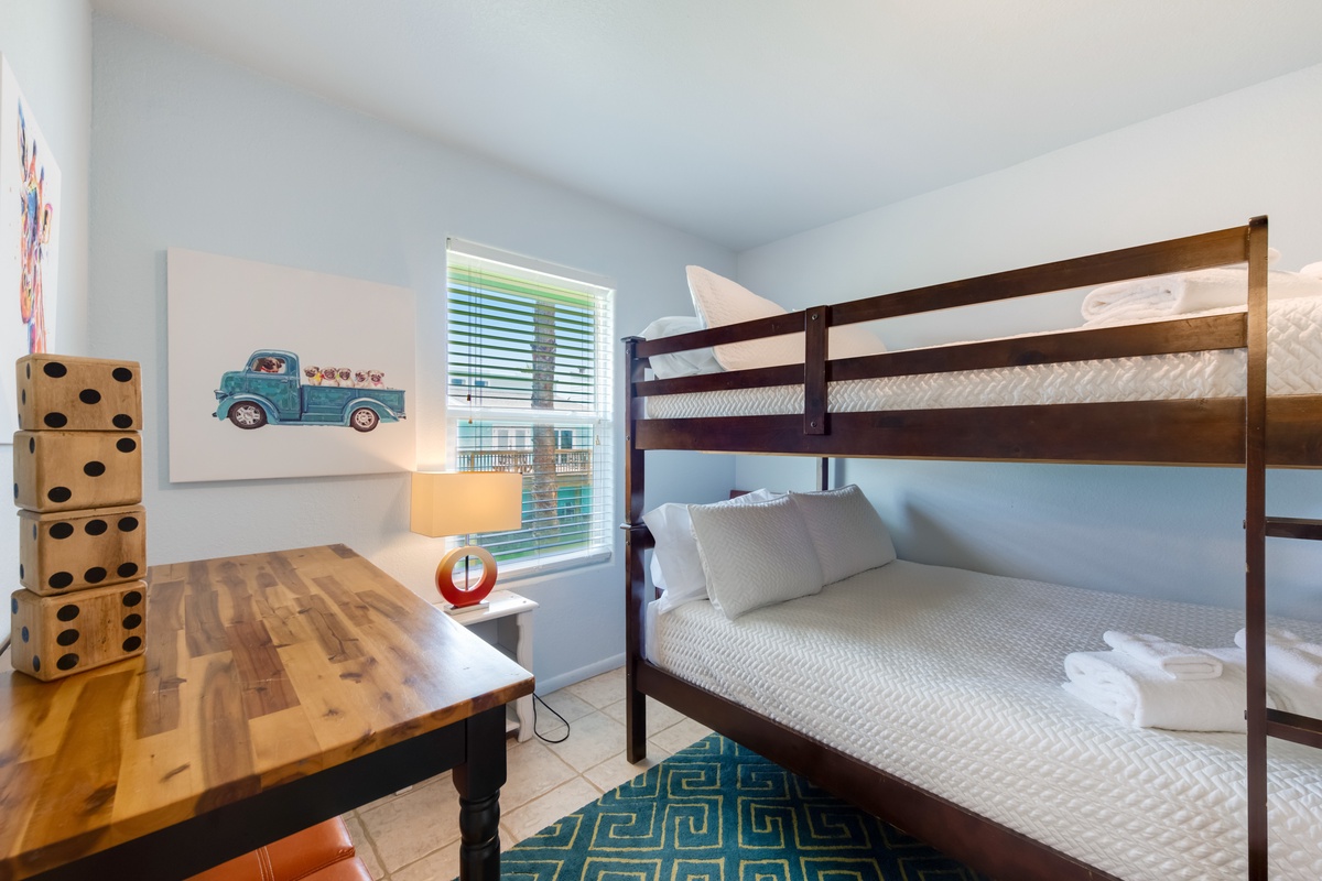 Your kids will love this playful bunk room with fun artwork, giant dice, and cozy beds ready for adventure-filled dreams.