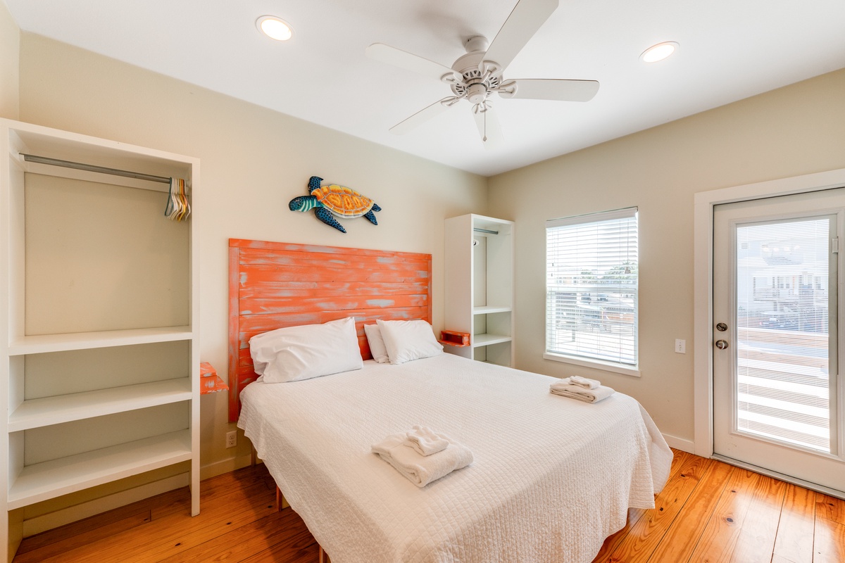 Your cozy bedroom features warm hardwood floors, beach-inspired decor, and fresh towels awaiting your arrival.