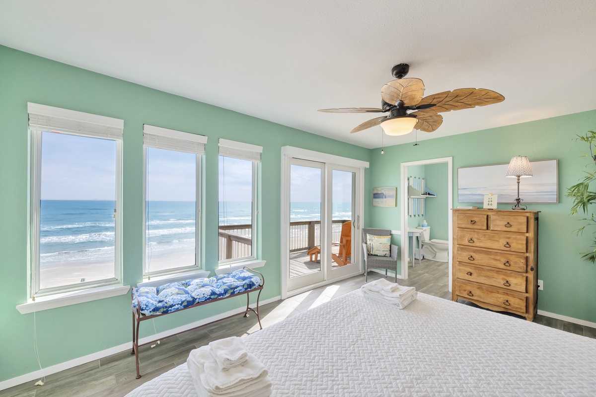 Wake to ocean waves through panoramic windows in your tranquil bedroom, where sea breezes flow through sliding doors to your private balcony.