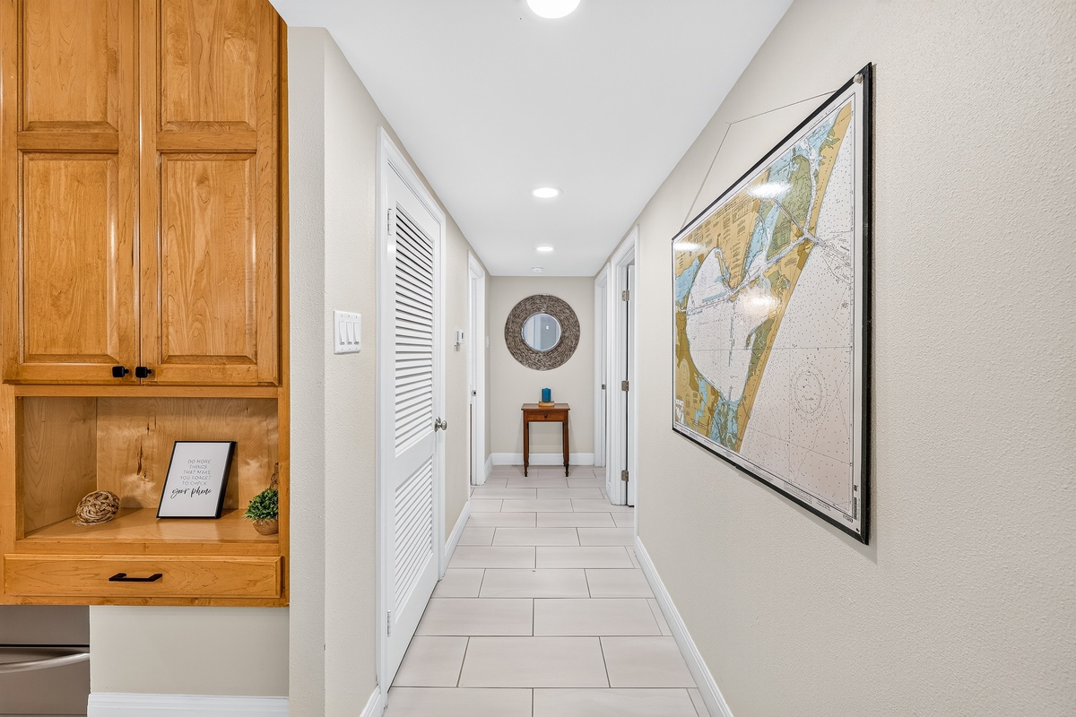 Step into your bright, coastal-inspired hallway with custom cabinetry and nautical chart decor that sets the perfect vacation tone.