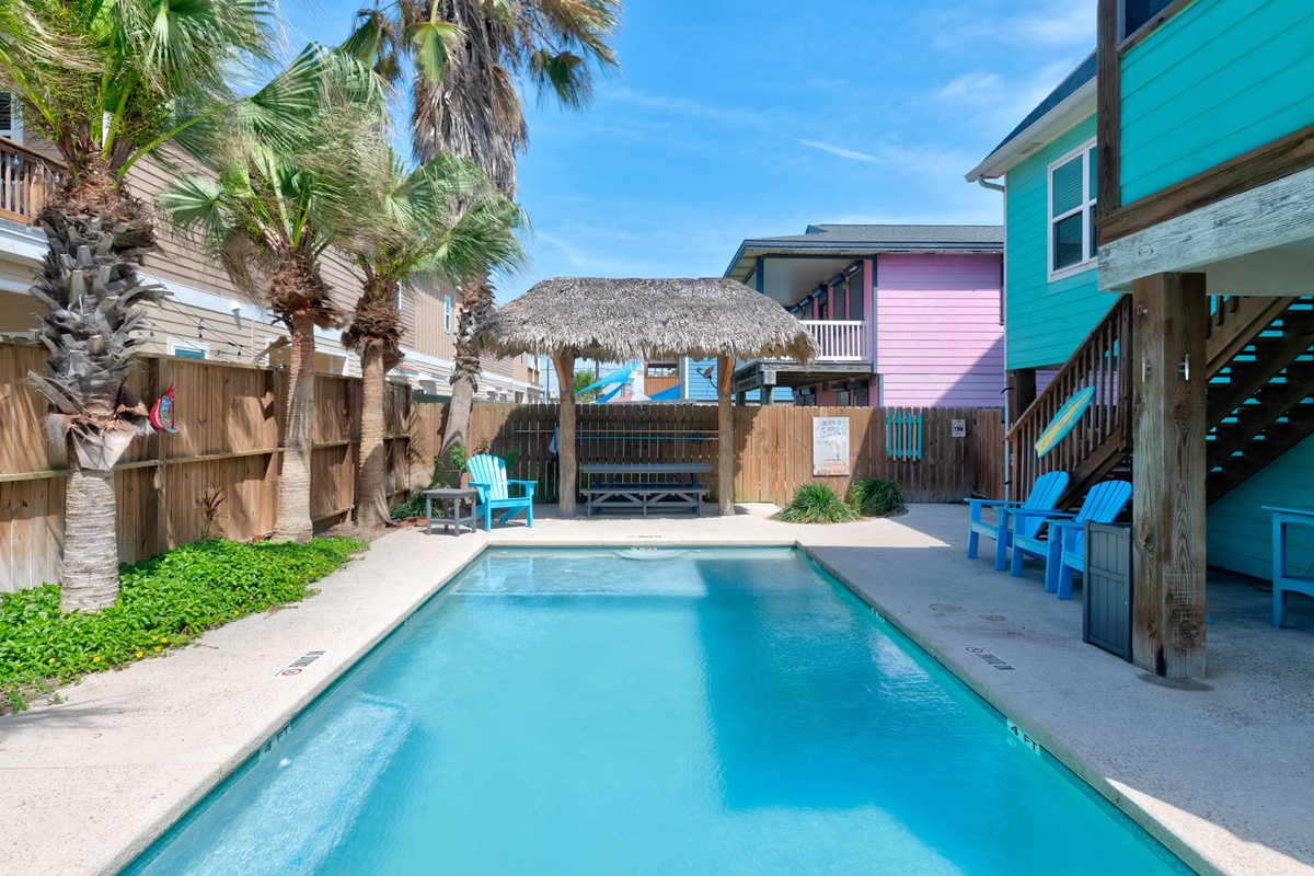 Dive into your private tropical oasis! This sparkling pool beckons beneath swaying palms, with cozy seating and a thatched cabana for ultimate relaxation.