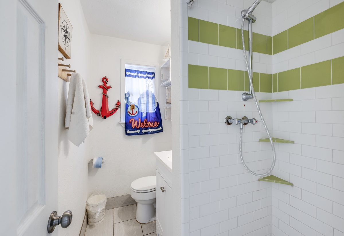 Refresh in your bright nautical bathroom featuring crisp white subway tiles and cheerful green accents, complete with shower and modern fixtures.
