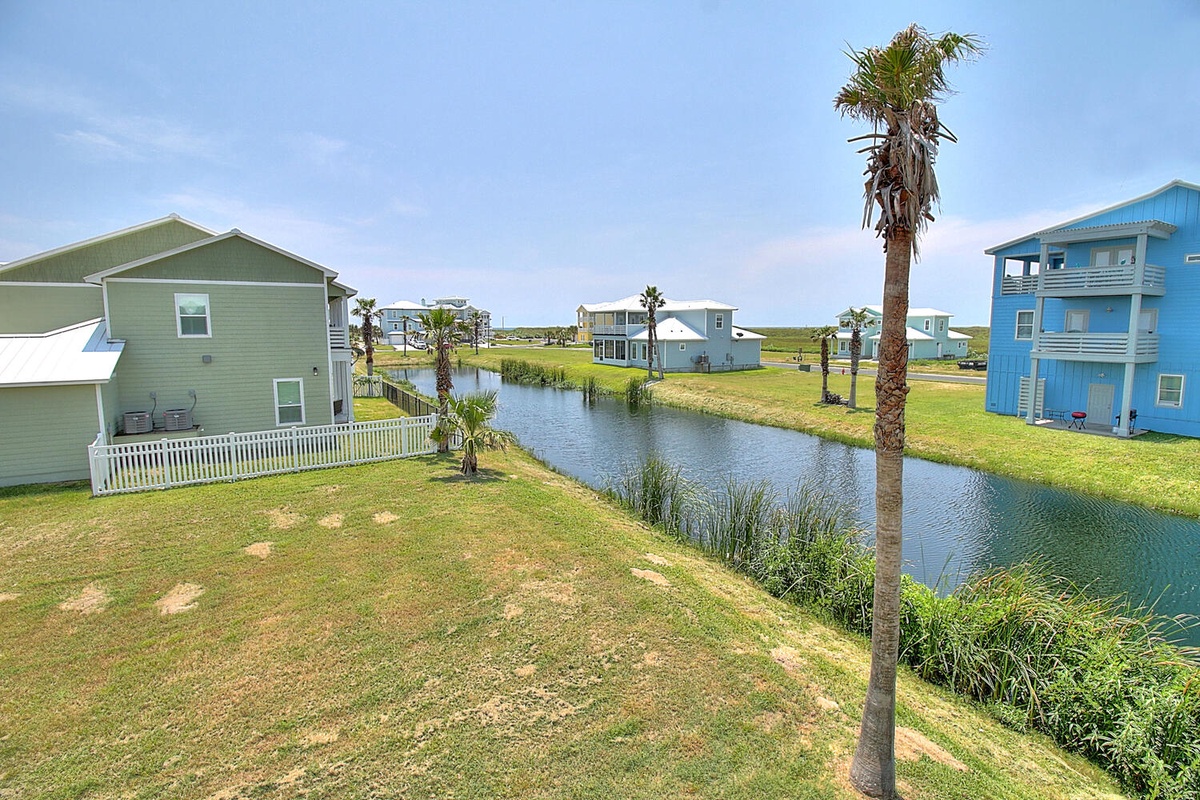 Coastal community with colorful vacation homes surrounding a peaceful canal, offering a tranquil waterfront setting.