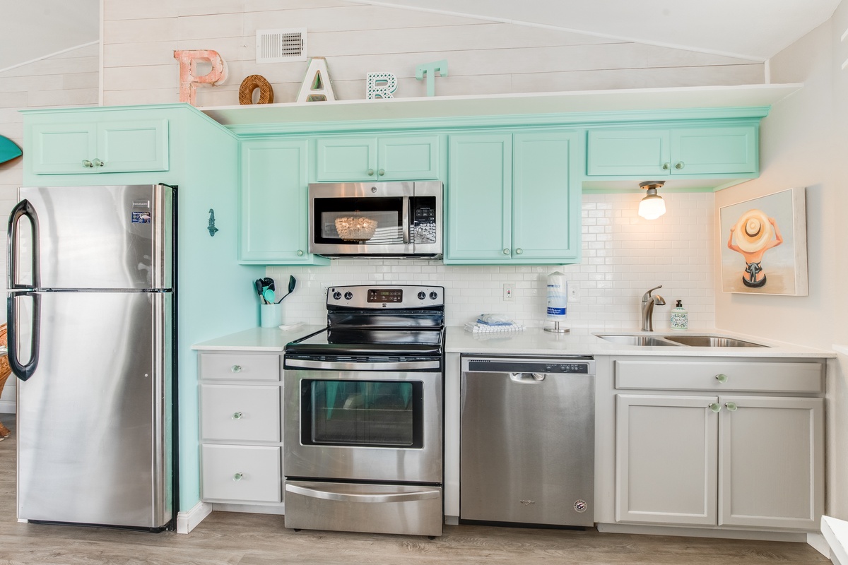 Your coastal-inspired kitchen features mint green cabinets and stainless steel appliances, creating a fresh space for preparing memorable meals.