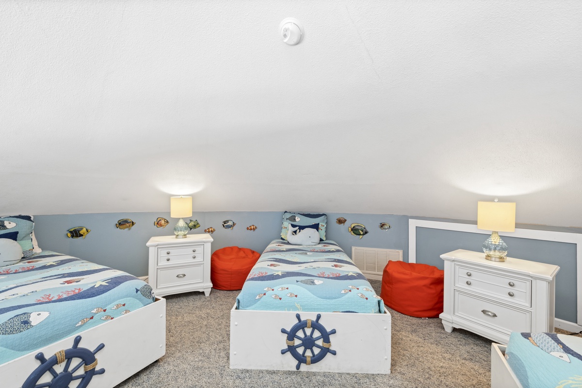 Your kids will love this nautical-themed bedroom with twin beds, playful sea life wall decals, and cozy reading bean bags.