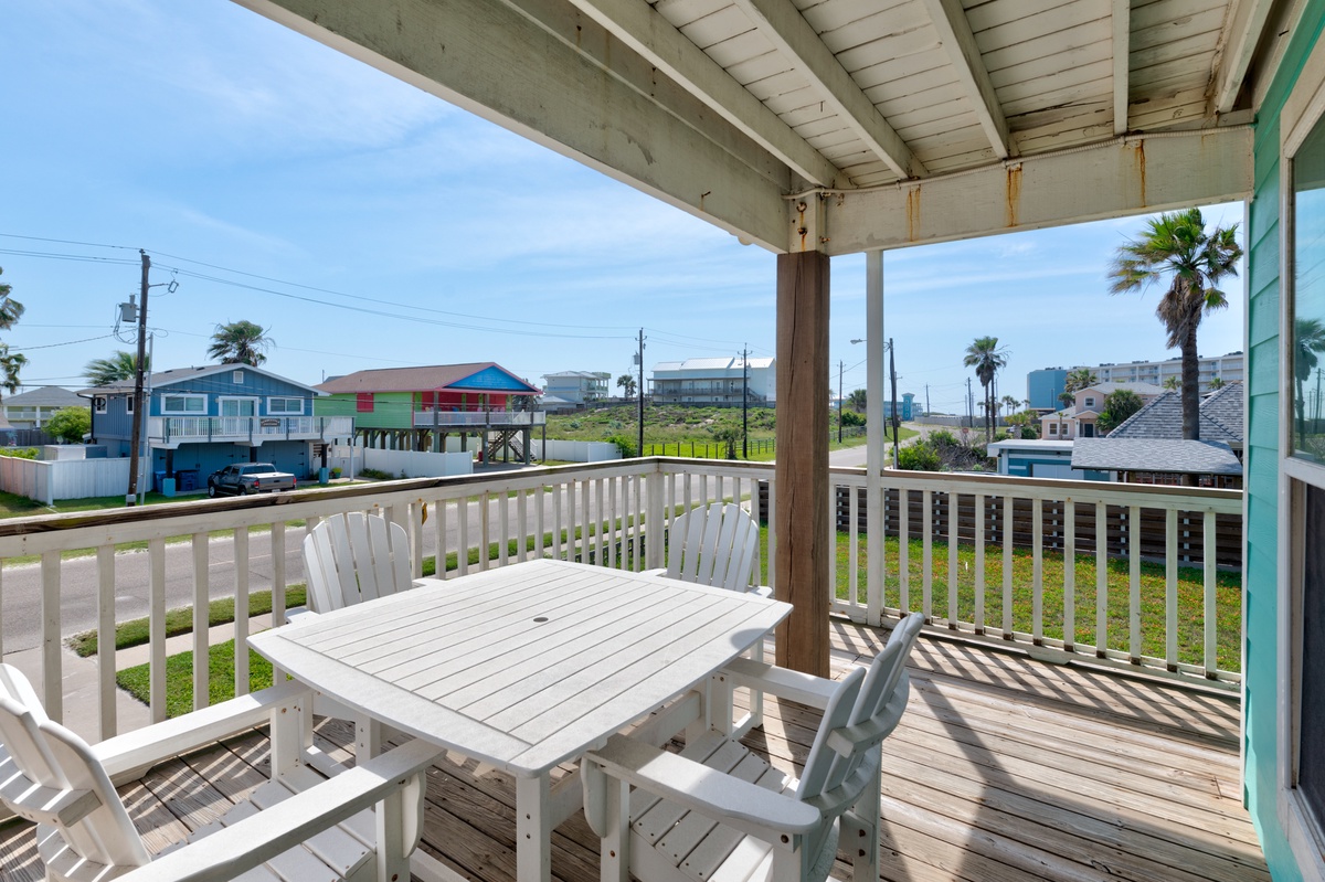 Your private deck offers panoramic views of colorful beach houses and swaying palms, perfect for morning coffee or evening relaxation.