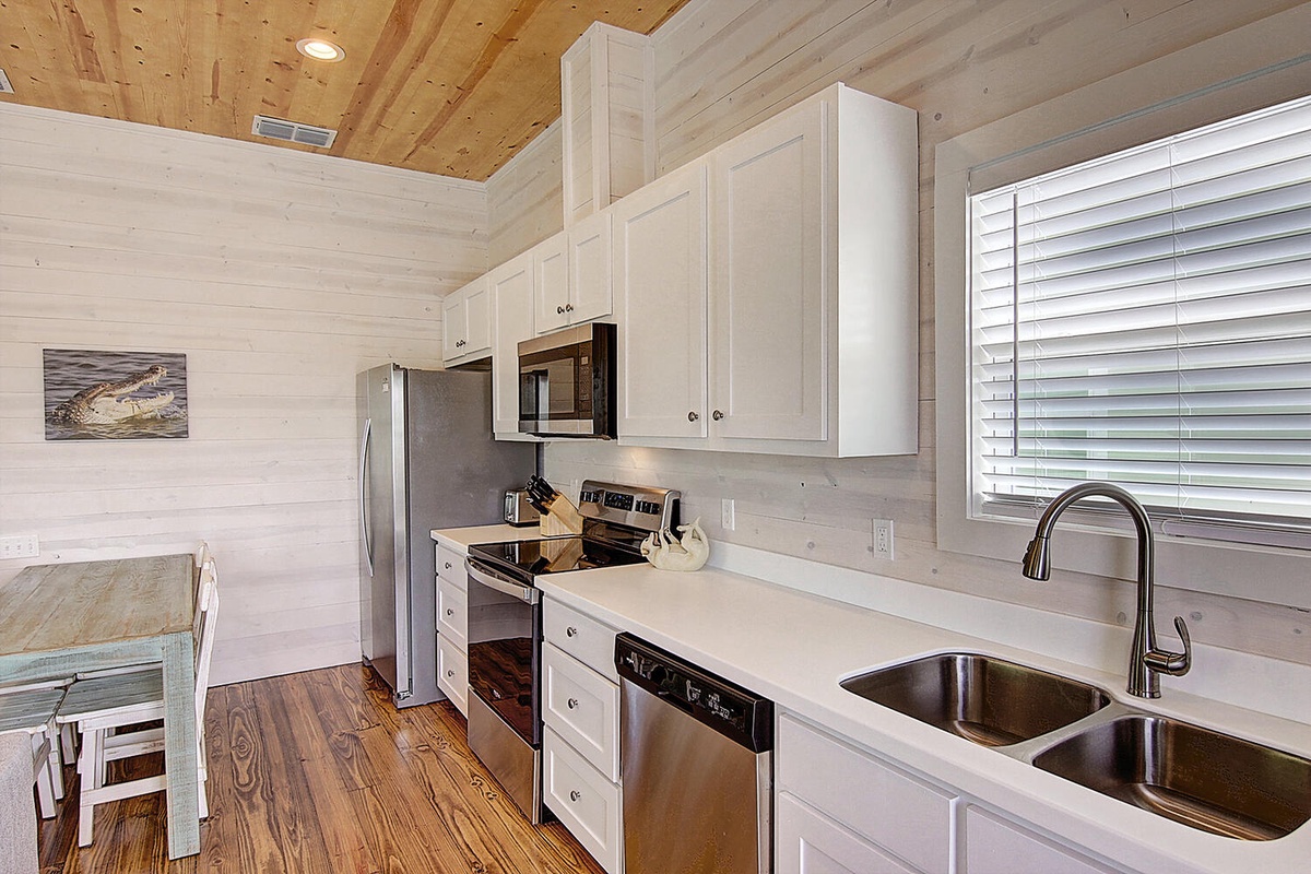 Your fully equipped kitchen features stainless steel appliances and white cabinetry, perfect for preparing memorable meals during your stay.
