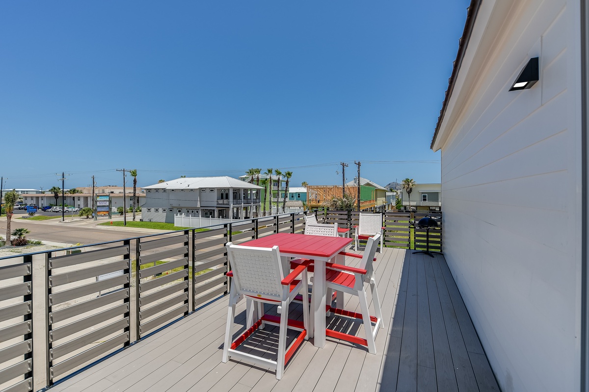Step onto your private balcony with vibrant red seating to enjoy morning coffee with neighborhood views.