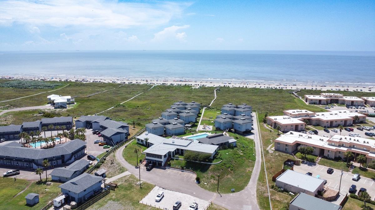 Aerial view of beachfront vacation rentals with direct beach access and coastal amenities in a peaceful seaside community.