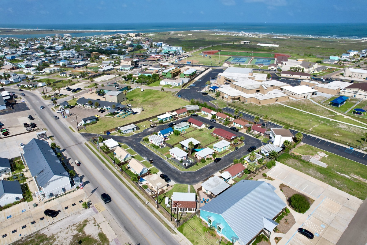 Aerial view of a coastal community with residential neighborhoods, schools, and recreational facilities near the ocean.