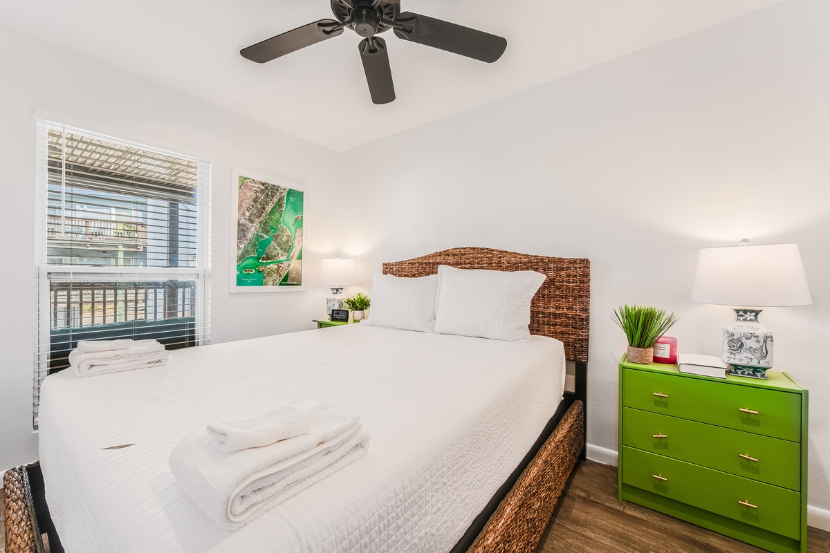 Unwind in your bright bedroom with crisp white linens and tropical touches. The ceiling fan keeps you cool while natural light creates the perfect atmosphere.