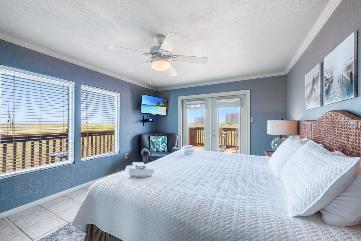 Wake up to coastal views from your bright bedroom with comfortable bedding, ceiling fan, and French doors to your private balcony.