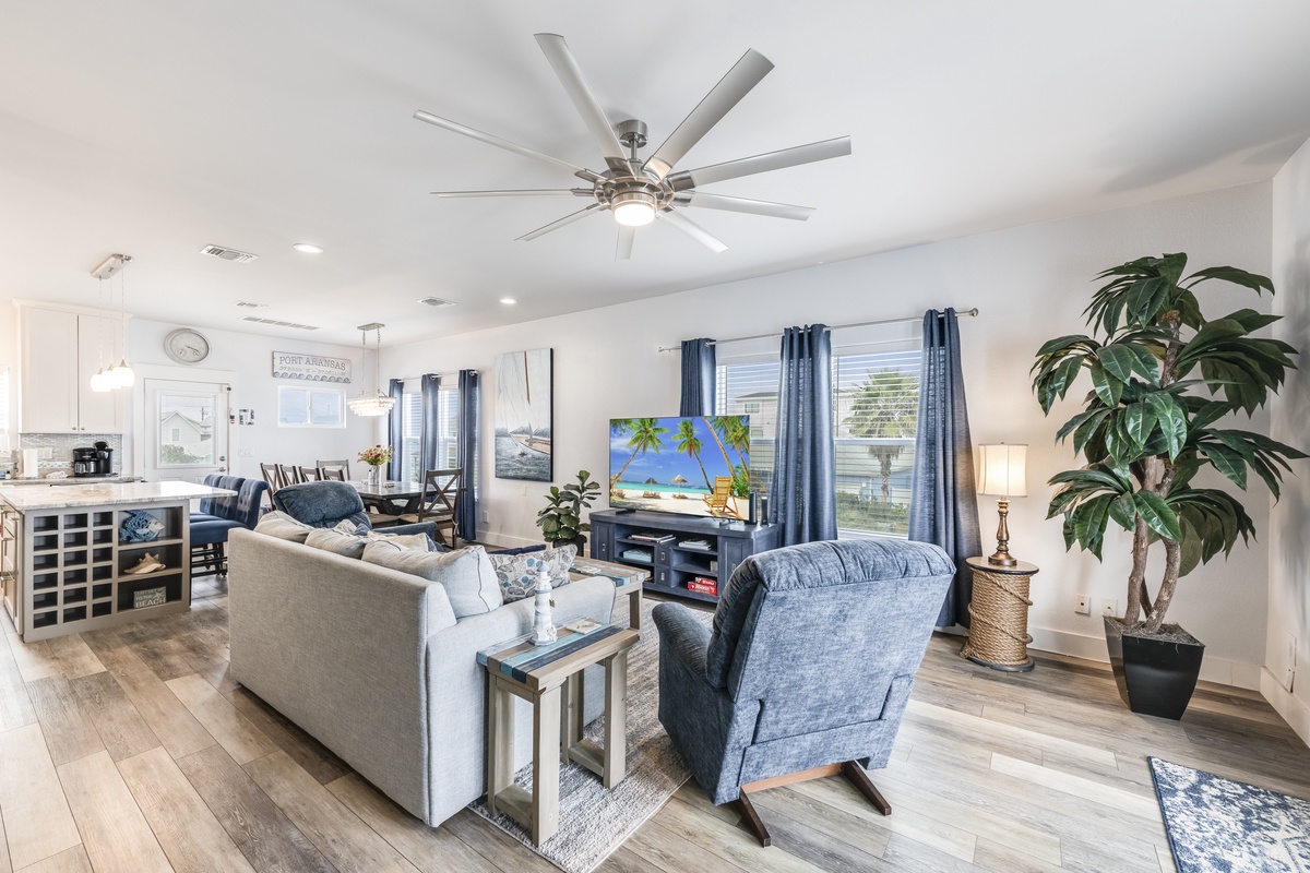Unwind in your spacious living area with plush seating, entertainment center, and stylish coastal décor that creates the perfect atmosphere for relaxing evenings.