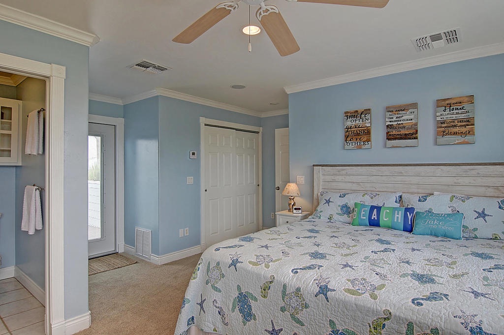 Your beachy bedroom retreat features coastal blues, sea turtle bedding, and gentle ceiling fan breezes for peaceful nights.