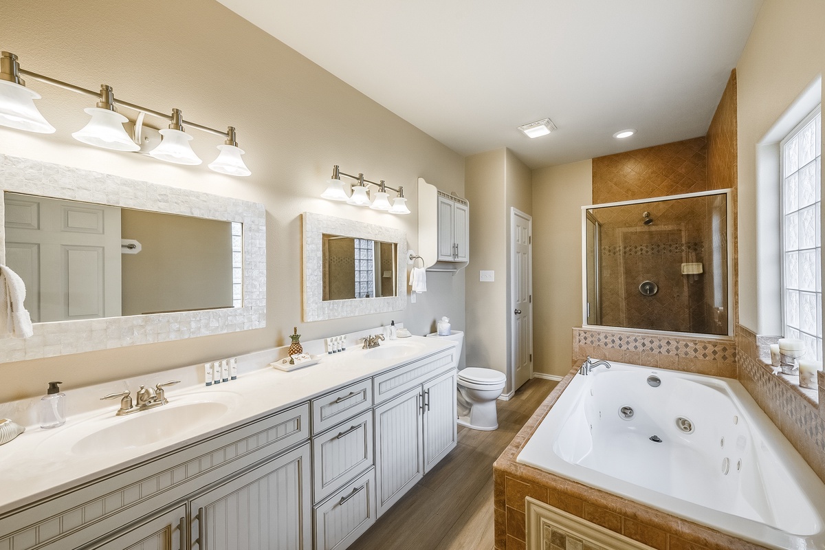 Indulge in your spacious master bathroom featuring dual vanities, a luxurious jetted tub, and elegant finishes that create the perfect retreat.