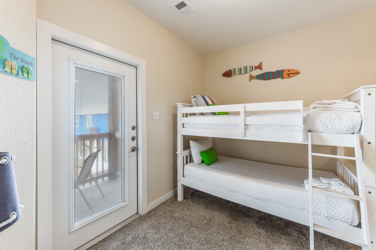 Your kids will love this cheerful bunk room with beach-themed decor and private balcony access.