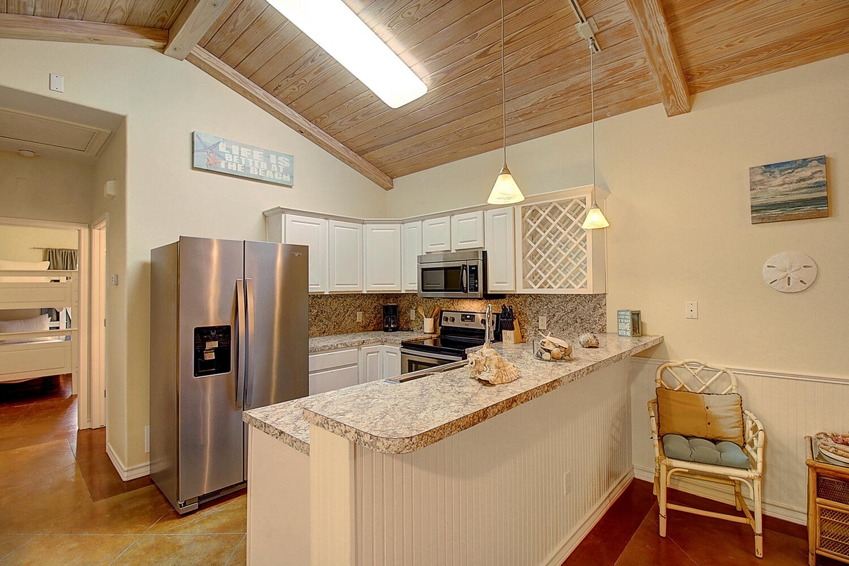 Your open kitchen awaits with granite counters, stainless appliances, and warm wood ceilings for memorable meal prep moments.