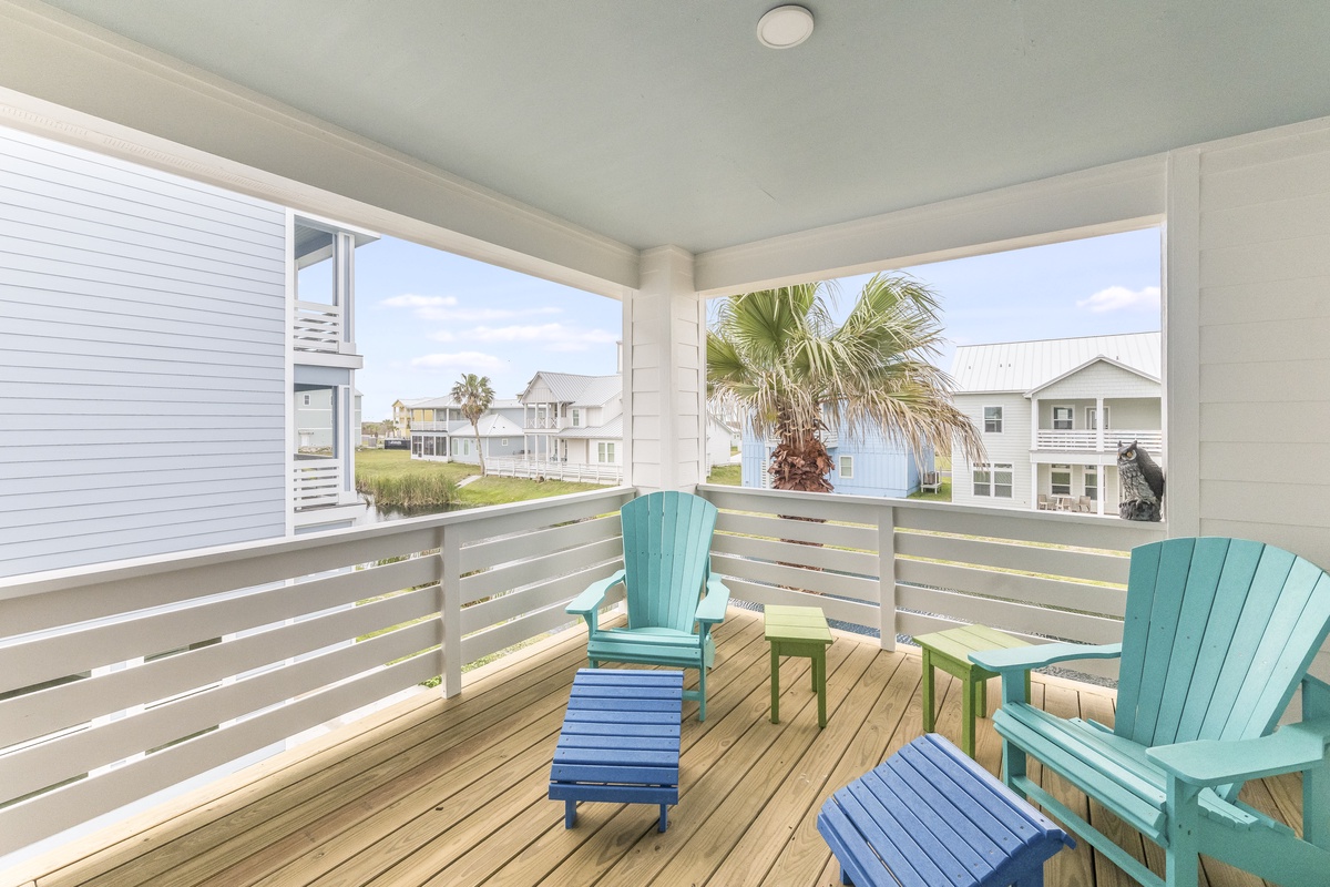 Unwind on your private balcony with colorful Adirondack chairs, where ocean breezes and tropical views create the perfect coastal retreat.