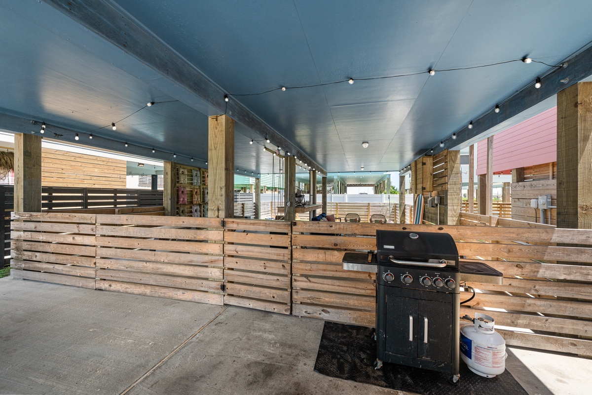 Fire up the grill and gather with friends under twinkling string lights in your private covered BBQ area, where rustic wood fencing creates an intimate outdoor dining retreat.