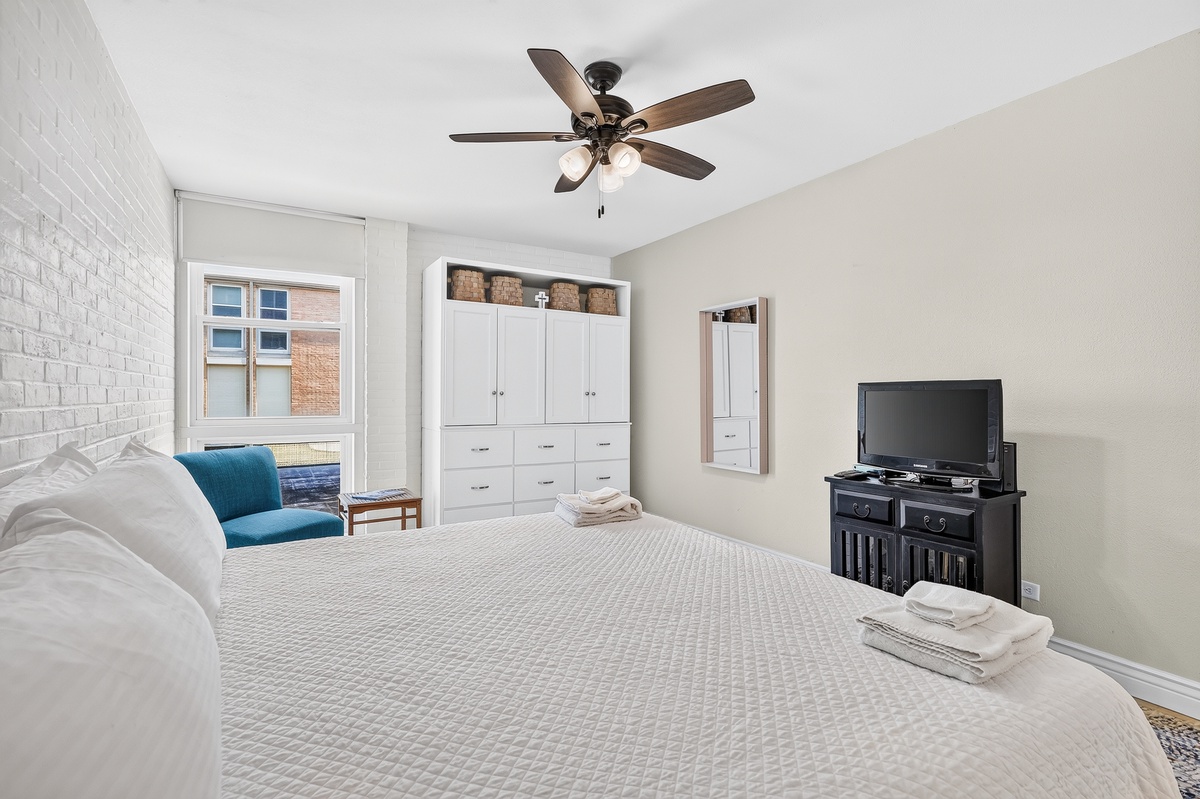 Slip into crisp, comfortable bedding and feel right at home in this bright, inviting bedroom. A cozy reading chair awaits by the window, while thoughtful storage keeps your belongings perfectly organized throughout your stay.