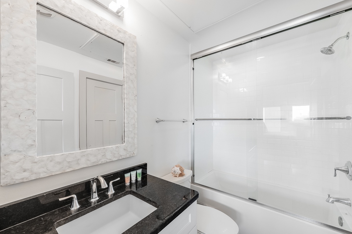 Step into your pristine marble bathroom with sleek granite counters and a spacious tub-shower combo for your perfect morning routine.