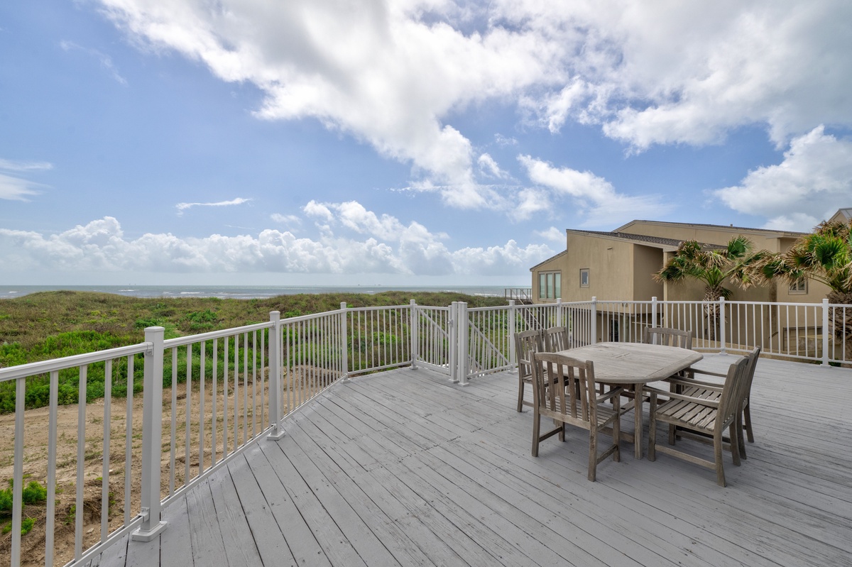 Spacious beachfront deck with ocean views and dining table for memorable coastal meals.